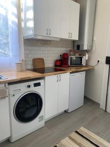 una cocina con lavadora y microondas en Cosy studio in Portes de Paris, en Les Lilas