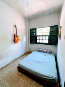 a bedroom with a bed and a guitar on the wall at República Engenho Quarto Casal in Ouro Preto