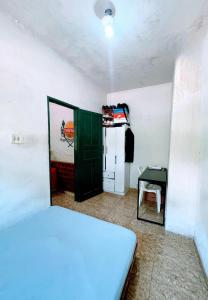 a bedroom with a bed and a green door and a refrigerator at República Engenho Quarto Casal in Ouro Preto