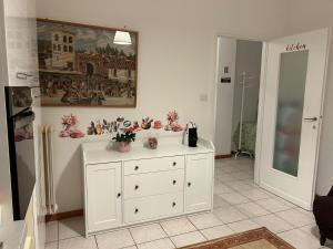 een kamer met een witte kast met bloemen erop bij Perfect Point Como in Lecco