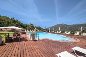 ein Swimmingpool auf einer Holzterrasse mit Liegestühlen in der Unterkunft Casena Mongerrati in Collesano