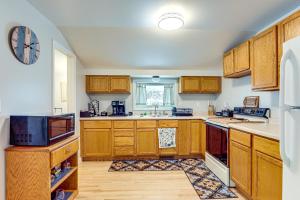 a kitchen with wooden cabinets and a refrigerator at 4 Mi to Lake Superior Calumet Getaway! in Calumet