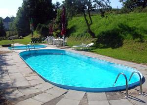 uma grande piscina com água azul num quintal em Hotel Valaskuv Grunt em Bouzov