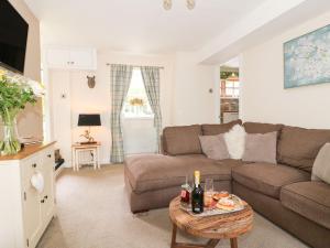 a living room with a couch and a table at Loft Cottage in Bedale