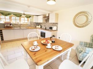 a kitchen and dining room with a wooden table and chairs at Loft Cottage in Bedale +17 photos