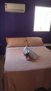 a bedroom with a bed with a flower on it at Raizes da Terra - Ponta do Corumbau in Corumbau