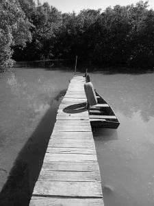 a boat sitting on a dock in the water at Raizes da Terra - Ponta do Corumbau in Corumbau