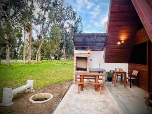 a patio with a grill and a table and a picnic table at La Encantada Cabañas in Cajamarca