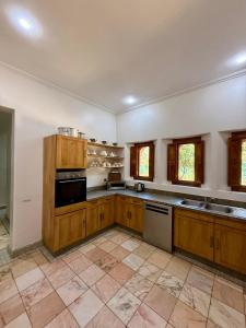 a large kitchen with wooden cabinets and appliances at VILLA 34 - 4 Masters, Moroccan Charm & Modern Comfort with Private Pool in Marrakesh
