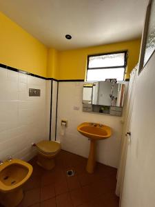 een badkamer met toilet en wastafel bij Casa Barracas, habitación privada in Buenos Aires