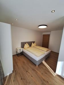 um quarto com uma cama num quarto com pisos em madeira em chalet10 em Samnaun