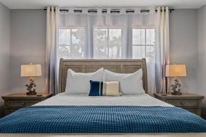Un dormitorio con una cama grande con dos mesitas de noche y dos ventanas. en Skyblue Villas, en Haines City 44 fotos más
