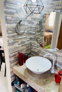 a bathroom with a sink and a mirror at Apartamento em condomínio para a COP30 in Marituba