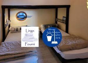 a room with two beds and a sign that saysnance in a bedroom at La goélette - Les Gîtes de la Côte d'Amour in Le Croisic