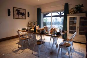 a dining room table and chairs with food on it at LA DOLOREANNE in Saint-Didier-sur-Chalaronne