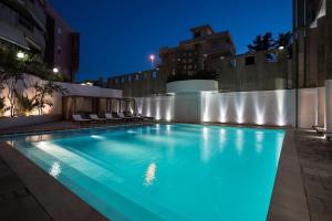a large swimming pool with blue lighting in a building at Salento IBIZA in Gallipoli