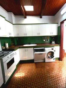 Una cocina con gabinetes blancos y lavadora. en Aloe Apartament 2 plus 1 gratis w Casa Verde de Guía, en Santa María de Guía de Gran Canaria
