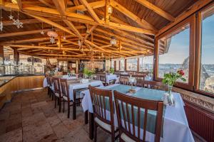 een eetkamer met tafels en stoelen en ramen bij Ascension Cave Suites - Special Class in Goreme