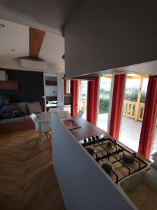 a kitchen with a stove top oven next to a living room at MHVACANCES 2 LOUENT PLUSIEURS MOBILHOMES DANS CAMPING 4 ETOILES PROCHE CHATEAUX et ZOO BEAUVAL in Onzain