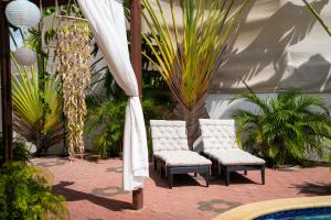 two chairs and an umbrella next to a pool at Casa Leonore II in Willemstad