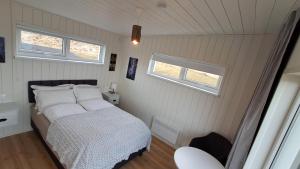 华姆斯唐吉Sauðá Guesthouse的带一张床和两扇窗户的卧室
