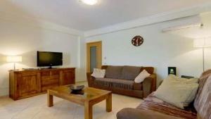 ein Wohnzimmer mit Sofa und Fernseher in der Unterkunft Vilamoura - Apartment near Mariana & Falesia Beach in Quarteira