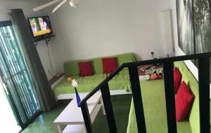 SonnenlandにあるSonneland 340のリビングルーム(赤い枕と緑のソファ付)