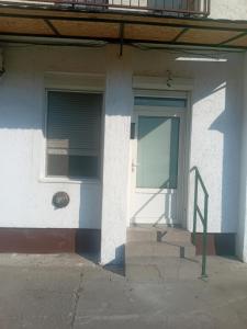 um edifício branco com uma porta e uma janela em Sindi Apartman em Bačka Palanka