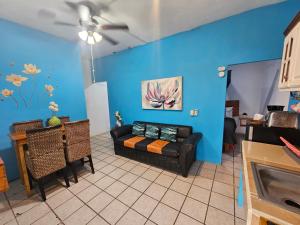 a living room with a couch and a blue wall at LOS SAUCES STUDIO in Puerto Vallarta