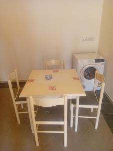 巴奇卡帕兰卡Sindi Apartman的桌椅、洗衣机和洗衣机