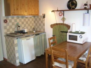 a small kitchen with a table and a microwave at Ligoracce in Castellina Marittima
