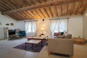 a living room with a couch and a table at Douceur Uzétienne Appartement de Caractère Climatisé in Uzès +35 photos
