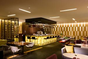 a restaurant with tables and chairs and a bar at Ramada Plaza by Wyndham Suwon in Suwon