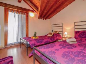 two beds in a room with purple sheets at Soffio Di Rugiada in Fonteno