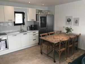 a kitchen with a table with chairs and a refrigerator at Apartment White House in Vinišće