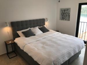 a bedroom with a large white bed with two pillows at Apartment White House in Vinišće