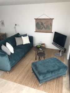 a living room with a blue couch and a tv at Apartment White House in Vinišće
