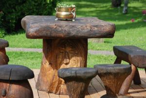 une table faite d'une mâchoire d'arbre avec un pot au-dessus dans l'établissement Hallikivi Tourist Farm, à Vennarti