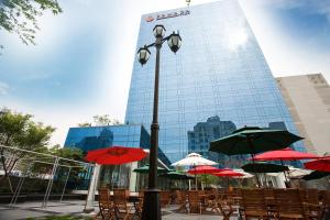 a street light with tables and chairs with umbrellas at Ramada Plaza by Wyndham Suwon in Suwon