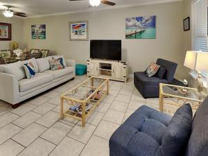 a living room with couches and a flat screen tv at 3 Sheets To the Zin in Port Aransas