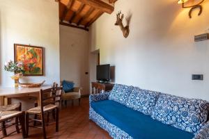 a living room with a blue couch and a table at Appartamento Fattoria in Laterina