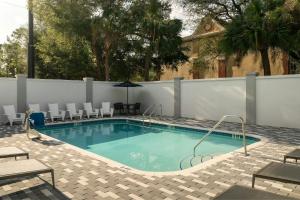 a swimming pool with chairs and a fence at Courtyard by Marriott Gainesville FL in Gainesville