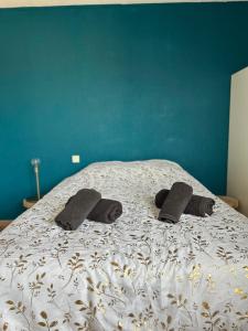a bed with two pairs of slippers on it at LE JULA - APPARTEMENT T2 PROCHE CENTRE VILLE - Parking privé in Albi