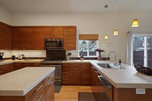 a kitchen with wooden cabinets and a sink at Dwell 30 Day Minimum in Bend