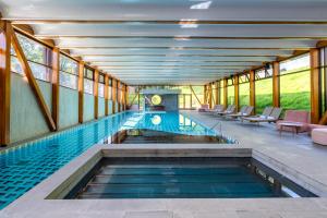 布鲁马迪纽Clara Arte的建筑物内的游泳池，配有桌椅