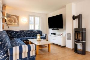 a living room with a couch and a tv at Reethaus Remy Luxus In Beckerwitz in Gramkow