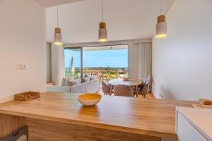 a kitchen with a table and a dining room at Condominio Bayline Gardens, Beach & SPA - Robalo by BEDZY in Armação de Pêra