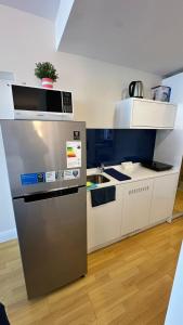 Orbi city mia luxury studio في باتومي: مطبخ مع ثلاجة من الفولاذ المقاوم للصدأ وحوض