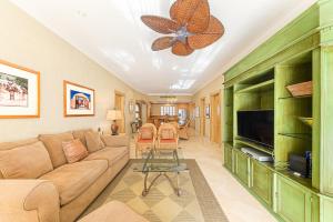 a living room with a couch and a flat screen tv at Villa La Estancia in Cabo San Lucas