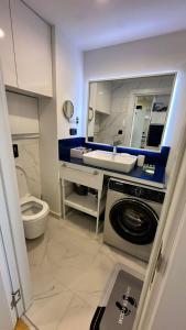 Orbi city mia luxury studio في باتومي: حمام مع مغسلة وغسالة ملابس
